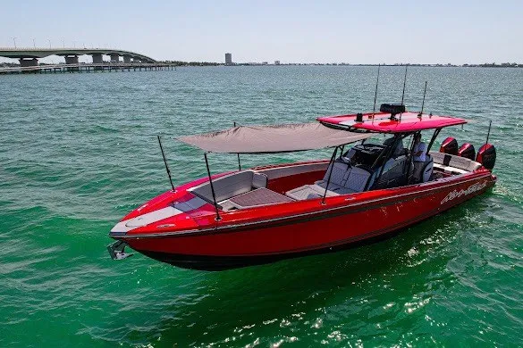 Slide: The Image of Red 2022 Nor-Tech 390 Sport boat on clear water with bridge in background. - 19