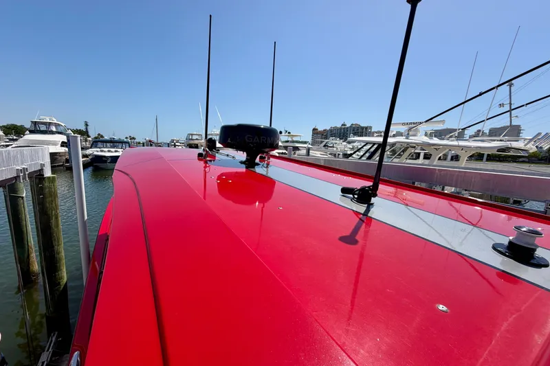 Slide: The Image of Red 2022 Nor-Tech 390 Sport boat docked, featuring sleek design and advanced navigation equipment. - 67