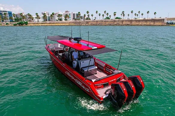 Slide: The Image of Red 2022 Nor-Tech 390 Sport boat cruising on a sunny day, with palm trees in the background. - 20