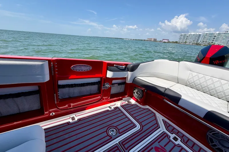 Slide: The Image of 2022 Nor-Tech 390 Sport boat interior with red accents, on a sunny day at sea. - 47