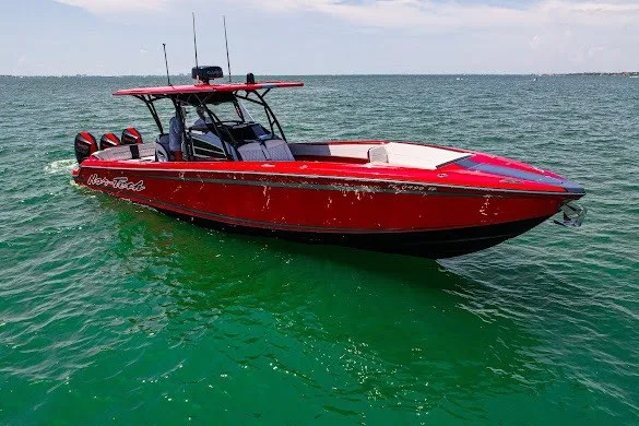 The Image of Red 2022 Nor-Tech 390 Sport boat on clear green water. - 1