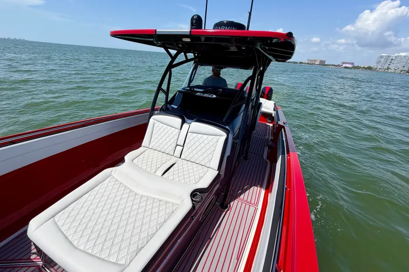 Slide: The Image of 2022 Nor-Tech 390 Sport boat with red accents cruising on open water. - 39
