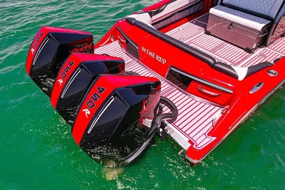 Slide: The Image of Red 2022 Nor-Tech 390 Sport boat with triple outboard engines on turquoise water. - 10