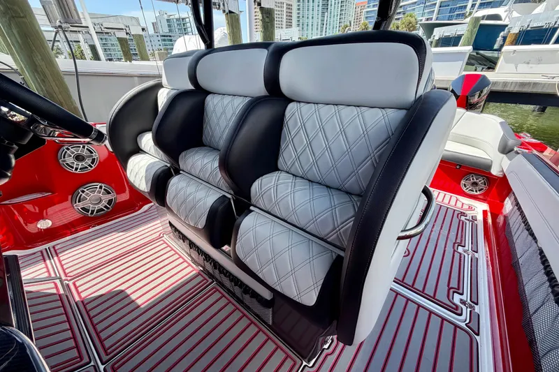 Slide: The Image of Luxury seating on 2022 Nor-Tech 390 Sport boat with quilted upholstery and vibrant red accents. - 56