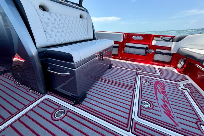 Slide: The Image of 2022 Nor-Tech 390 Sport boat interior with stylish seating and vibrant red accents. - 48