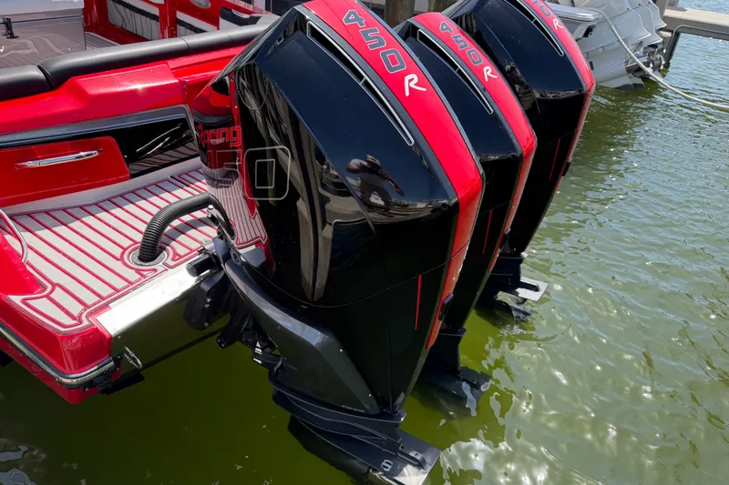 Slide: The Image of Triple Mercury 450R engines on a 2022 Nor-Tech 390 Sport boat, docked in water. - 69