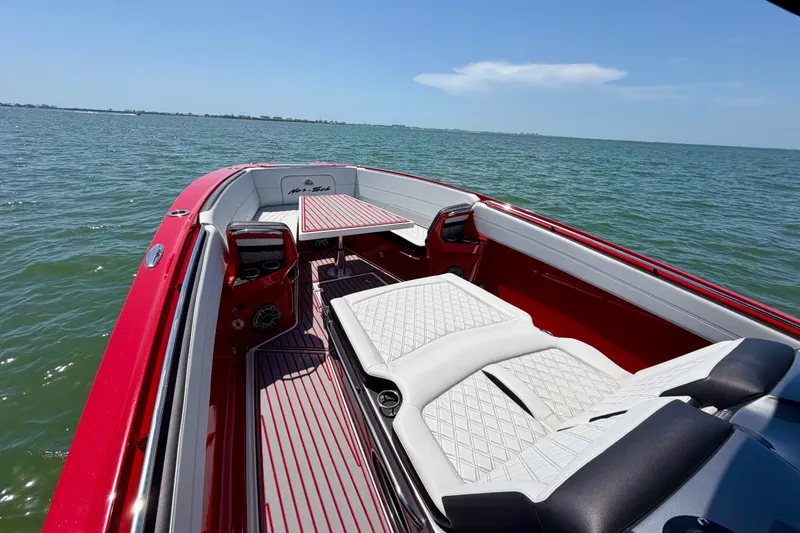 Slide: The Image of 2022 Nor-Tech 390 Sport boat with red and white interior on open water. - 32