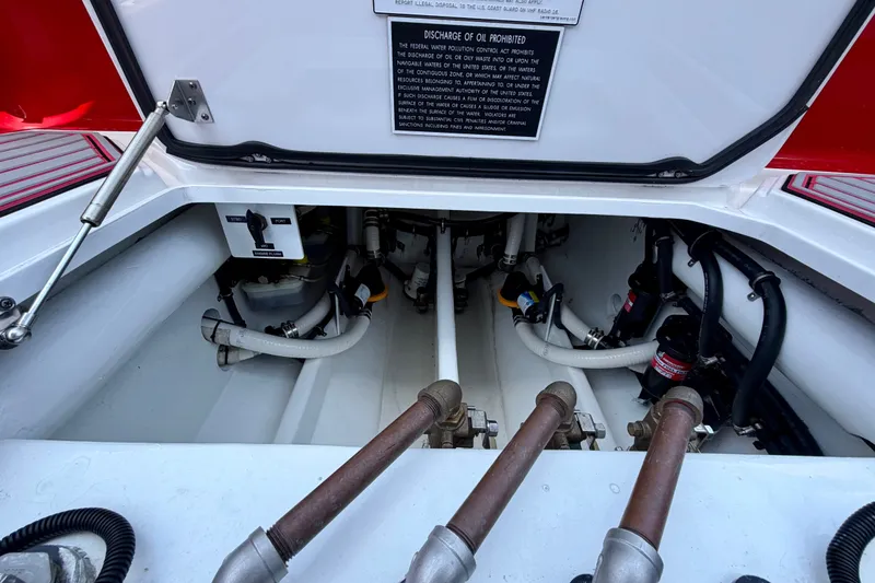 Slide: The Image of Engine compartment of 2022 Nor-Tech 390 Sport boat, showing hoses and mechanical components. - 63