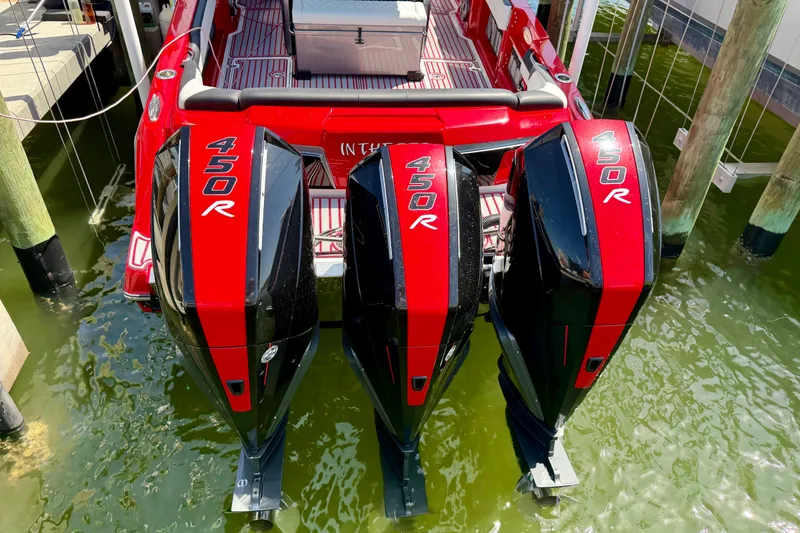 Slide: The Image of 2022 Nor-Tech 390 Sport with triple 450R engines docked in green water. - 70