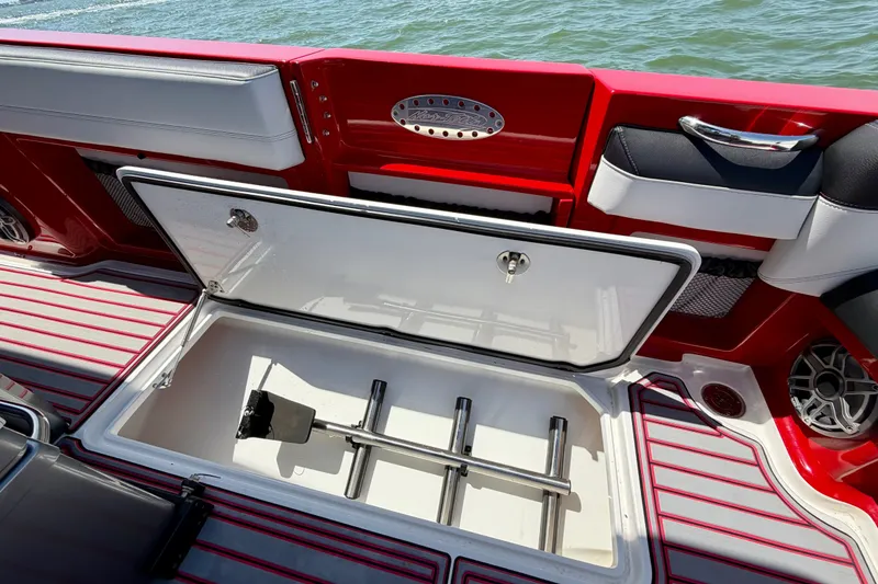 Slide: The Image of 2022 Nor-Tech 390 Sport boat interior with open storage compartment, red and white design. - 49