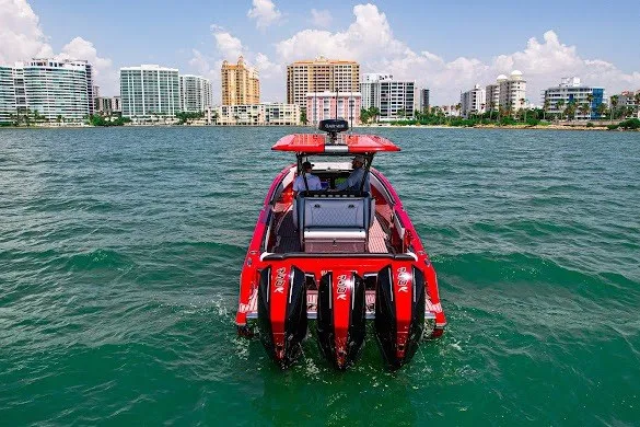 Slide: The Image of 2022 Nor-Tech 390 Sport boat with quad engines on vibrant water, city skyline backdrop. - 8