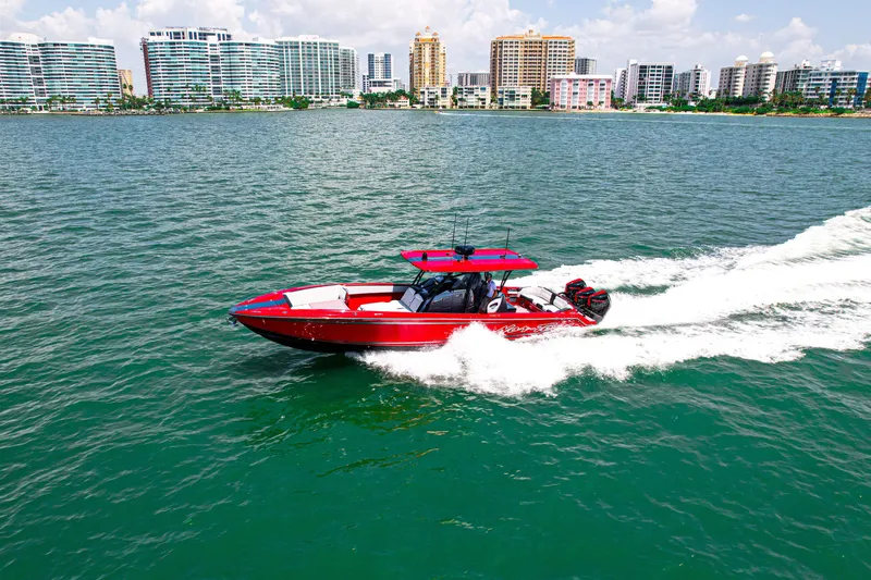 Slide: The Image of 2022 Nor-Tech 390 Sport boat cruising on water with city skyline backdrop. - 26