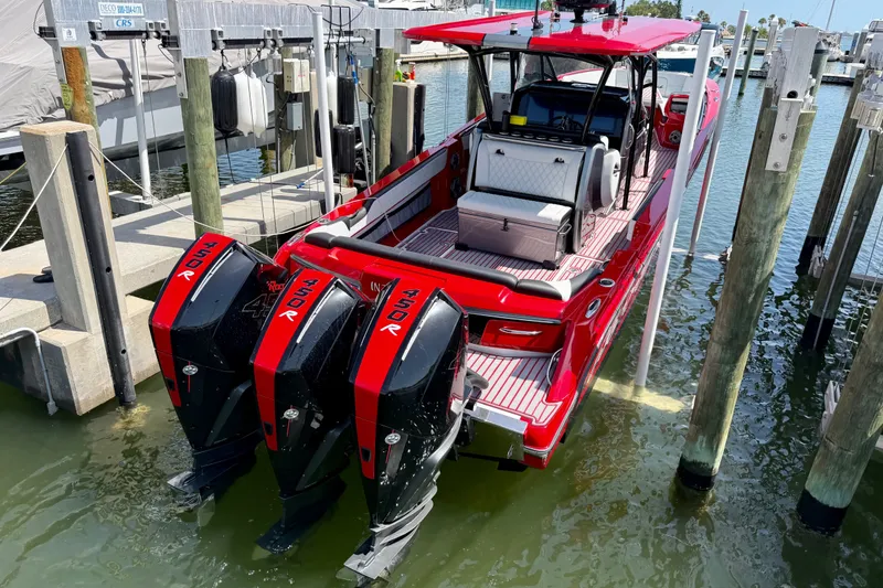 Slide: The Image of Red 2022 Nor-Tech 390 Sport boat docked with triple outboard engines. - 71