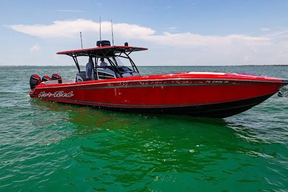 Slide: The Image of Red 2022 Nor-Tech 390 Sport boat on clear green water under blue sky. - 5
