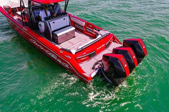 Slide: The Image of Red 2022 Nor-Tech 390 Sport boat with powerful twin engines cruising on clear green water. - 9
