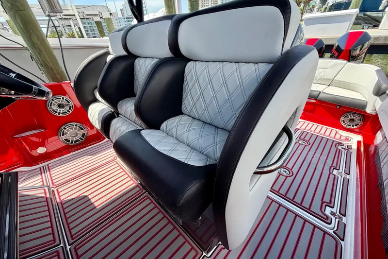 Slide: The Image of 2022 Nor-Tech 390 Sport boat interior with luxurious seating and vibrant red accents. - 57