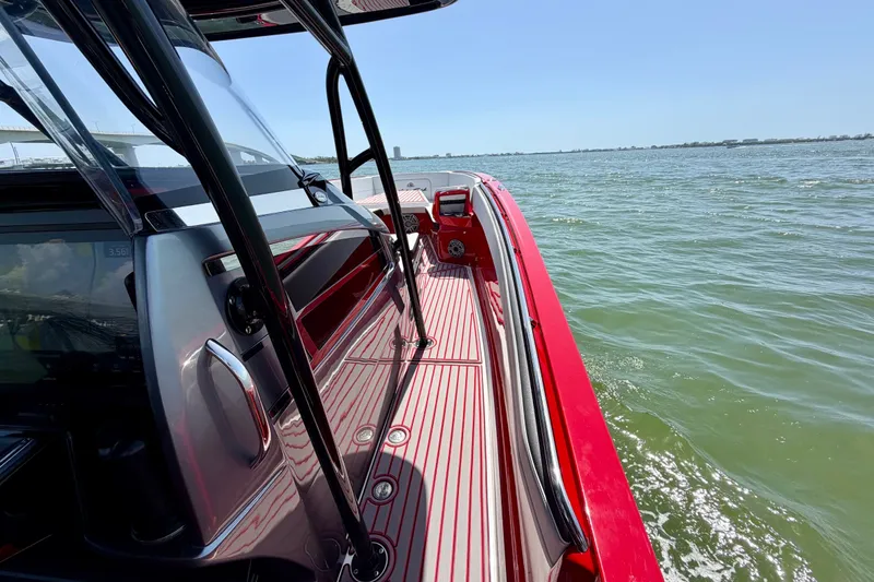 Slide: The Image of 2022 Nor-Tech 390 Sport boat cruising on open water, showcasing sleek red design. - 44