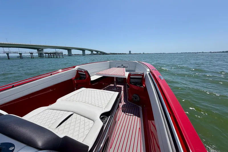 Slide: The Image of 2022 Nor-Tech 390 Sport boat on water near a bridge, featuring red and white interior. - 33