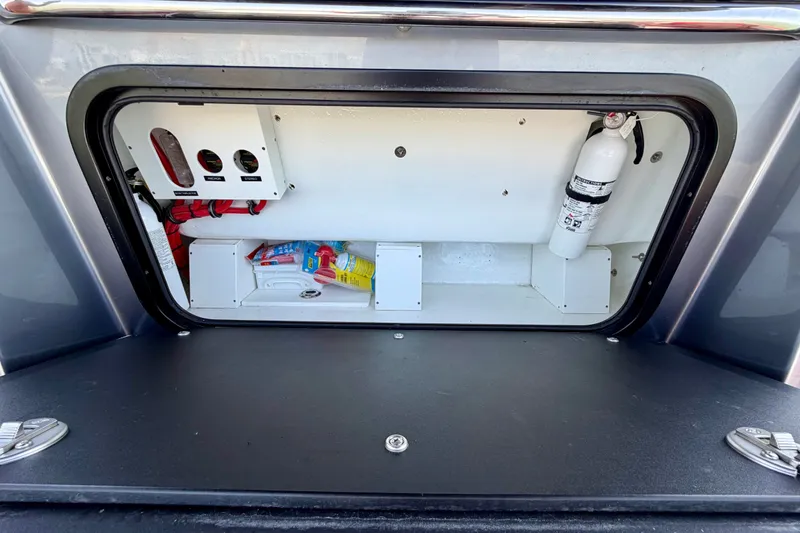 Slide: The Image of Storage compartment of 2022 Nor-Tech 390 Sport boat with fire extinguisher and supplies. - 64