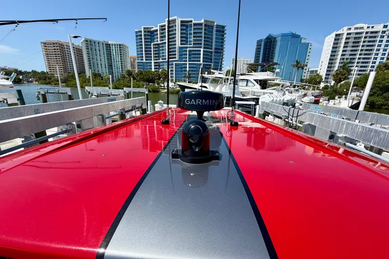 Slide: The Image of Red 2022 Nor-Tech 390 Sport boat docked, featuring Garmin equipment, with city skyline backdrop. - 66