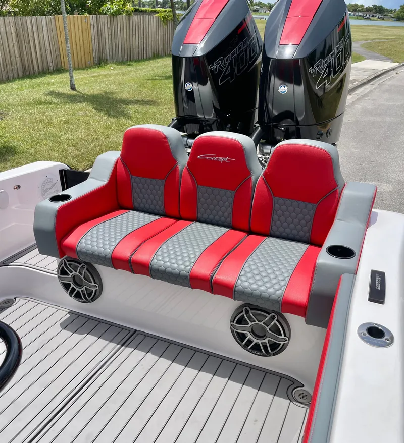 Slide: The Image of Red and gray bench seat on a boat with two outboard motors in the background. - 8