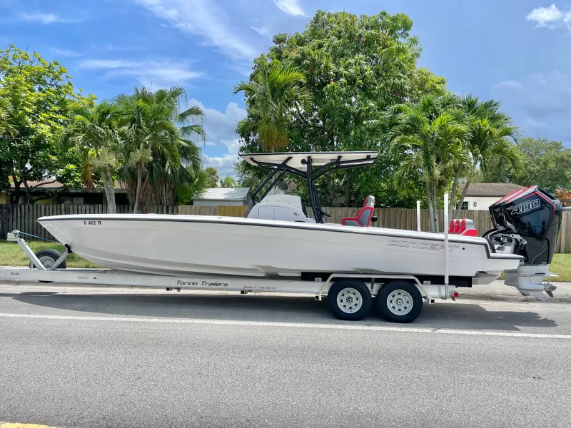 Slide: The Image of A white 32-foot boat on a trailer, surrounded by palm trees and a blue sky. - 4