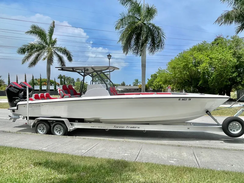 Slide: The Image of A white 32-foot boat on a trailer, surrounded by palm trees and a clear sky. - 2