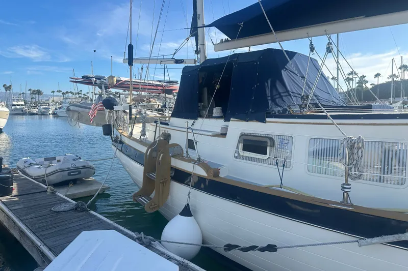Slide: The Image of 1977 Down East Yachts DownEaster 45 sailboat docked at marina under clear blue sky. - 6