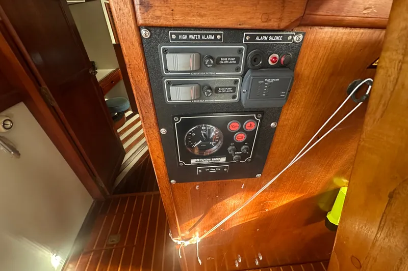 Slide: The Image of Control panel inside 1977 Down East Yachts DownEaster 45, featuring high water alarm and gauges. - 32