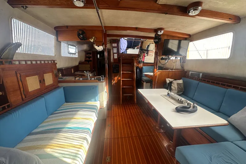Slide: The Image of Interior of a 1977 Down East Yachts DownEaster 45 with wood accents and blue seating. - 21