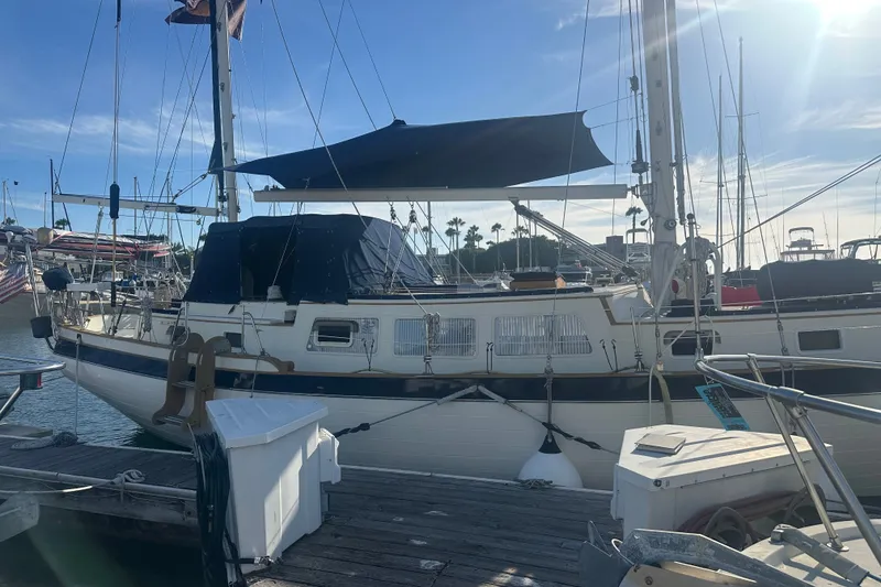 Slide: The Image of 1977 Down East Yachts DownEaster 45 sailboat docked at marina under clear blue sky. - 8