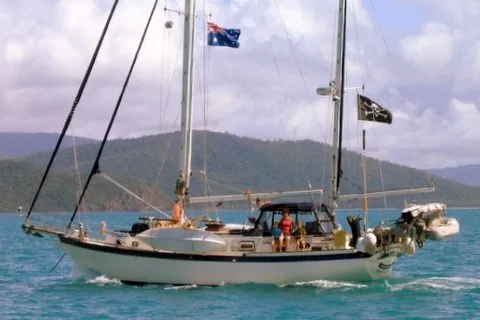 Slide: The Image of 1977 Down East Yachts DownEaster 45 sailboat on turquoise water with scenic mountain backdrop. - 1
