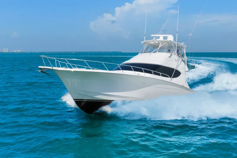 Slide: The Image of 2017 Hatteras GT54 yacht cruising swiftly on open blue ocean waters. - 15