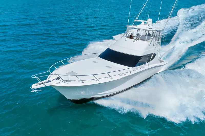 Slide: The Image of 2017 Hatteras GT54 yacht cruising on clear blue ocean waters. - 20