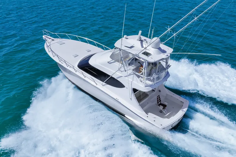 Slide: The Image of 2017 Hatteras GT54 yacht cruising on clear blue ocean waters. - 17