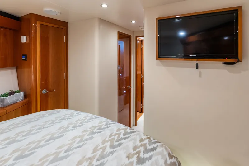 Slide: The Image of Luxurious interior of 2017 Hatteras GT54 yacht bedroom with TV and wooden accents. - 70