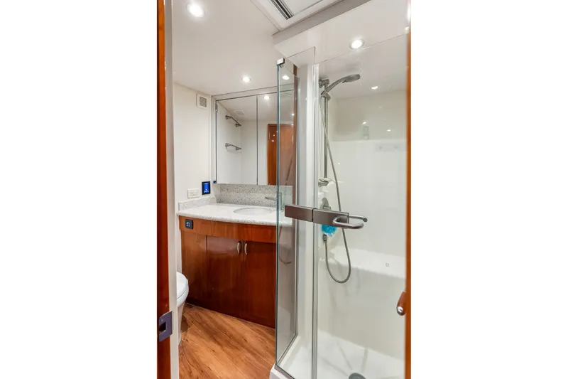 Slide: The Image of Bathroom interior of 2017 Hatteras GT54 yacht with glass shower and wooden cabinetry. - 65
