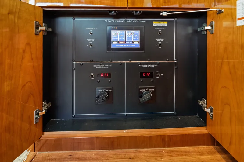 Slide: The Image of Electrical panel inside 2017 Hatteras GT54 yacht, featuring control switches and digital display. - 73