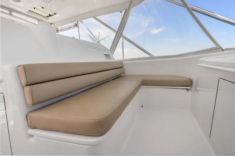 Slide: The Image of 2017 Hatteras GT54 yacht interior with beige cushioned seating and panoramic windows. - 29