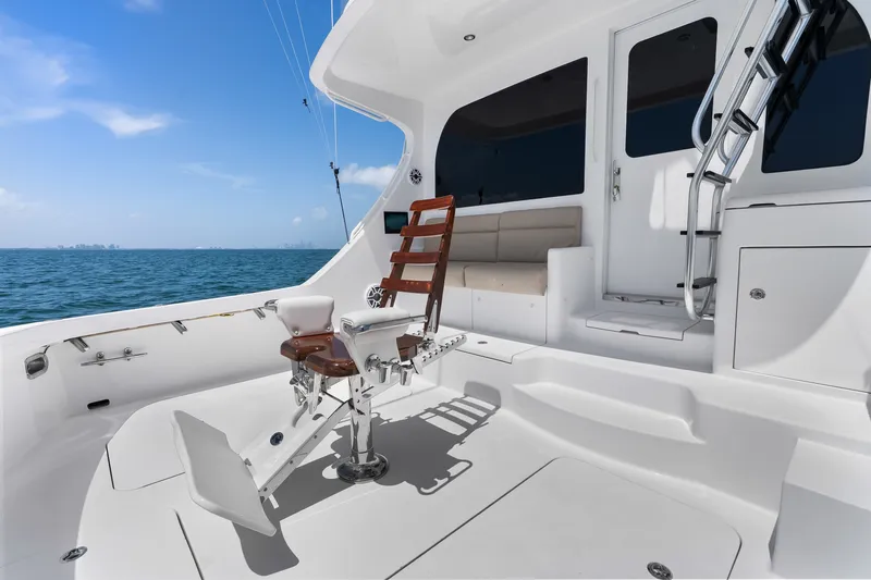 Slide: The Image of 2017 Hatteras GT54 yacht deck with fishing chair, ocean view, and clear blue sky. - 32