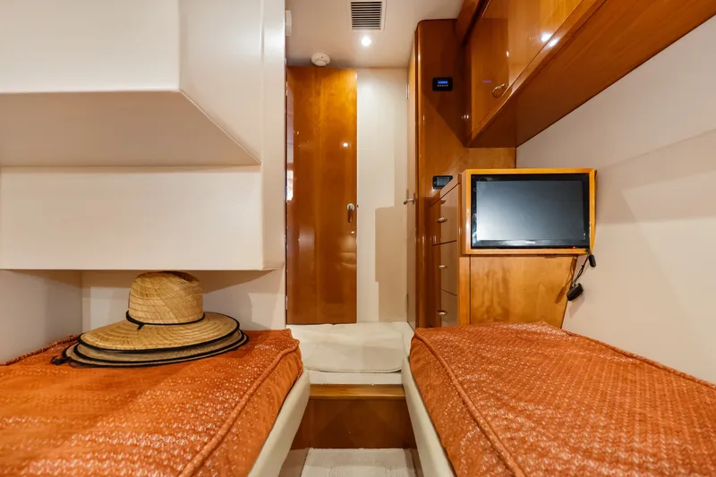 Slide: The Image of Luxurious 2017 Hatteras GT54 yacht cabin with twin beds, TV, and stylish decor. - 61