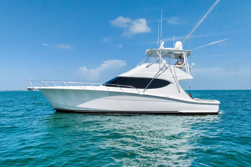 The Image of 2017 Hatteras GT54 yacht cruising on clear blue ocean waters under a sunny sky. - 0
