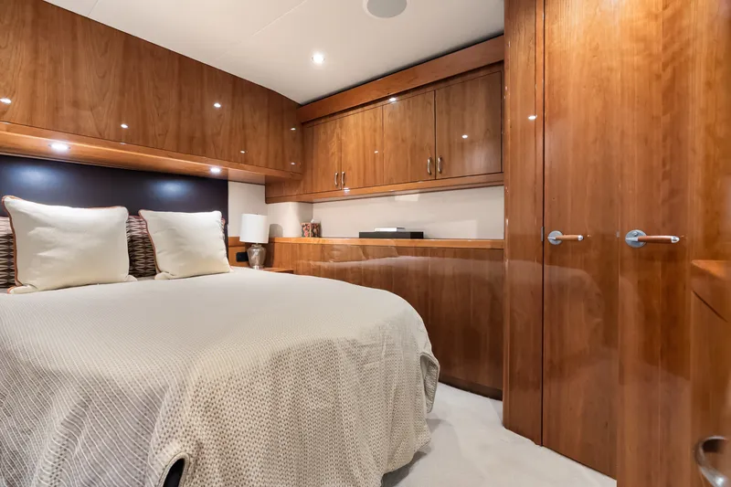 Slide: The Image of Luxurious 2017 Hatteras GT54 yacht bedroom with elegant wood cabinetry and cozy bedding. - 51