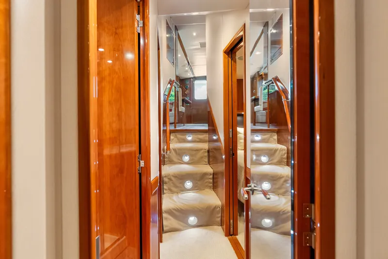 Slide: The Image of Interior of 2017 Hatteras GT54 yacht with polished wood and illuminated stairs. - 71