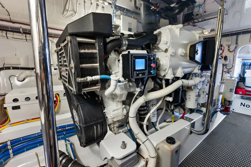 Slide: The Image of Engine room of a 2017 Hatteras GT54 yacht, showcasing complex machinery and wiring. - 88