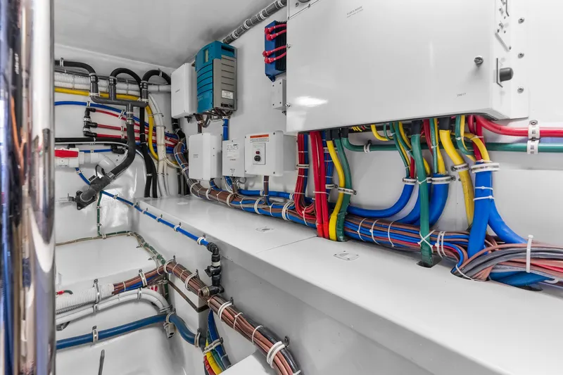 Slide: The Image of Engine room wiring of 2017 Hatteras GT54 yacht, showcasing organized cables and electrical systems. - 84