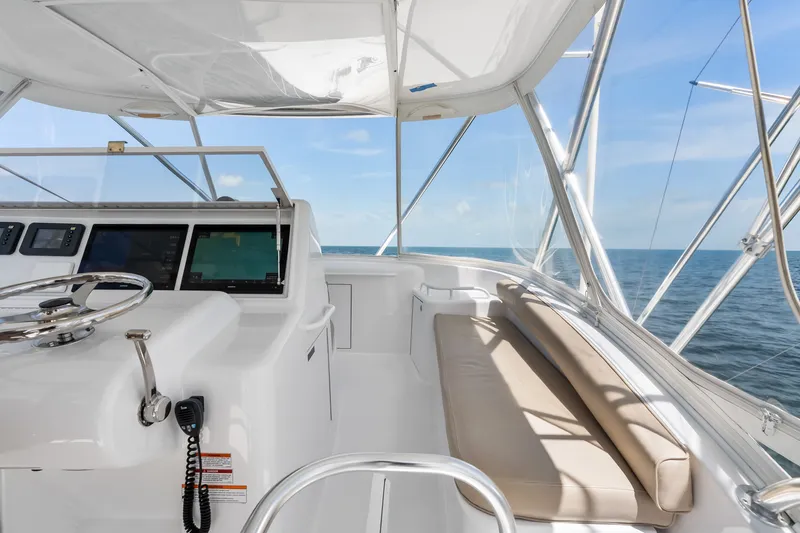 Slide: The Image of 2017 Hatteras GT54 yacht helm with ocean view, featuring modern controls and seating. - 24