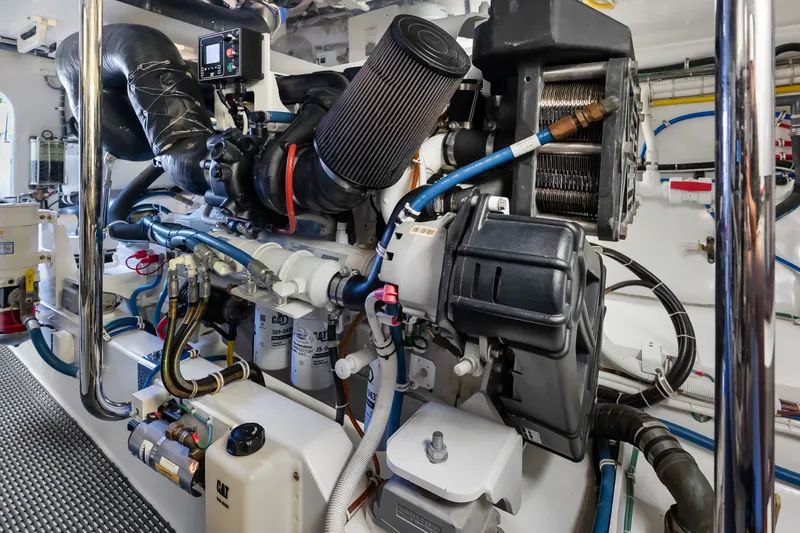 Slide: The Image of Engine room of a 2017 Hatteras GT54 yacht, showcasing complex machinery and components. - 89