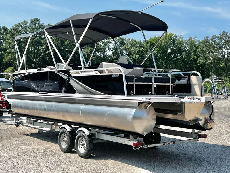 Slide: The Image of A modern pontoon boat with a black canopy and silver pontoons sits on a trailer. - 5