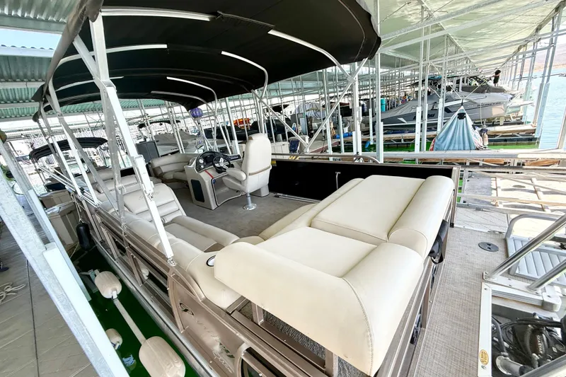 Slide: The Image of 2017 Bentley Pontoons 223 Elite Cruise with beige seating under a covered dock. - 18